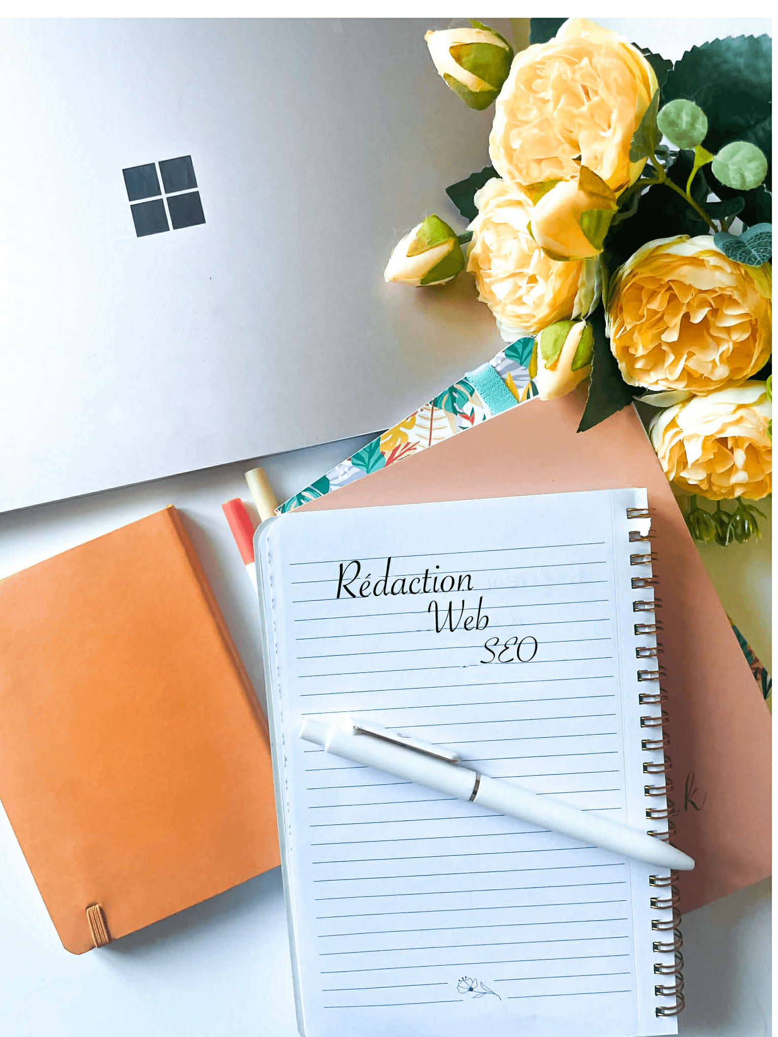 Carnet avec les mots rédaction web SEO écrits sur une page pour illustrer mon service
